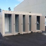 Innenansicht eines umgebauten Sanitärcontainers mit Waschbecken und Toiletten